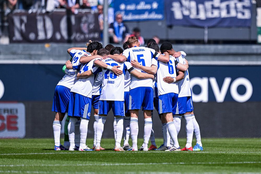 Die Mannschaft des FC Schalke 04 im Kreis vor einem Spiel. Trotz Bundesliga-Aufstieg landet der S04 bei den Fernsehgeldern offenbar nur auf Rang 17 hinter dem SC Paderborn. Foto: RHR-Foto